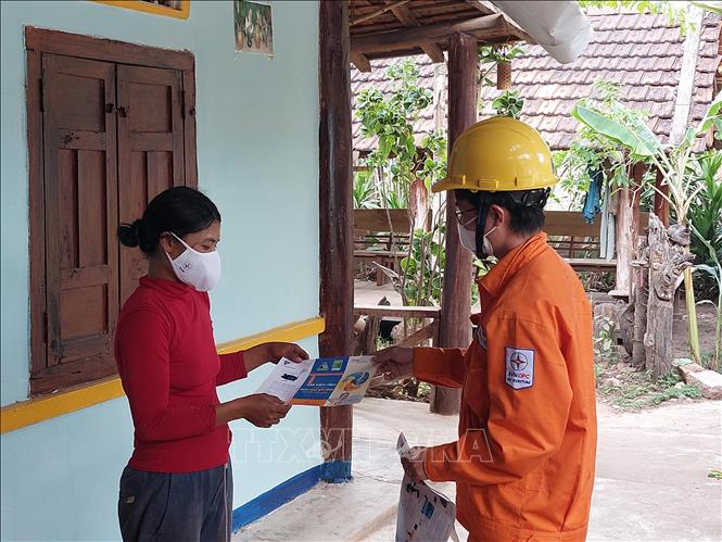 Công nhân Công ty Điện lực Kon Tum tuyên truyền, phát tờ rơi tại làng Kon Ktu (xã Đăk Rơ Wa, thành phố Kon Tum) nhằm nâng cao nhận thức của người đồng bào dân tộc thiểu số về tiết kiệm điện. Ảnh: Khoa Chương - TTXVN