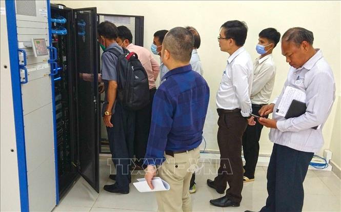 Đoàn công tác Uỷ ban hợp tác Lào - Việt cùng các bên liên quan kiểm tra hệ thống truyền dẫn phát sóng. Ảnh: Phạm Kiên-PV TTXVN tại Lào