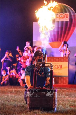 Kỹ thuật viên điều chỉnh ánh sáng theo điệu nhạc nền. Ảnh: Tuấn Anh - TTXVN