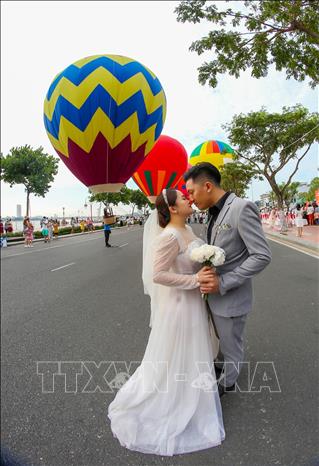 A couple chooses their wedding background as colourful hot air balloons. VNA Photo: Trần Lê Lâm 