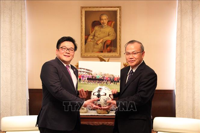 Trong ảnh: Ông Nguyễn Võ Huyền Dương, đại diện Liên đoàn Bóng đá Việt Nam (VFF) tại Nhật Bản, thay mặt đội tuyển Việt Nam tặng Đại sứ Vũ Hồng Nam ảnh đội tuyển và quả bóng có chữ ký của các tuyển thủ. Ảnh: Phạm Tuân-PV TTXVN tại Nhật Bản