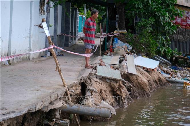 Một người dân địa phương tại vị trí sạt lở. Ảnh: Thanh Liêm - TTXVN