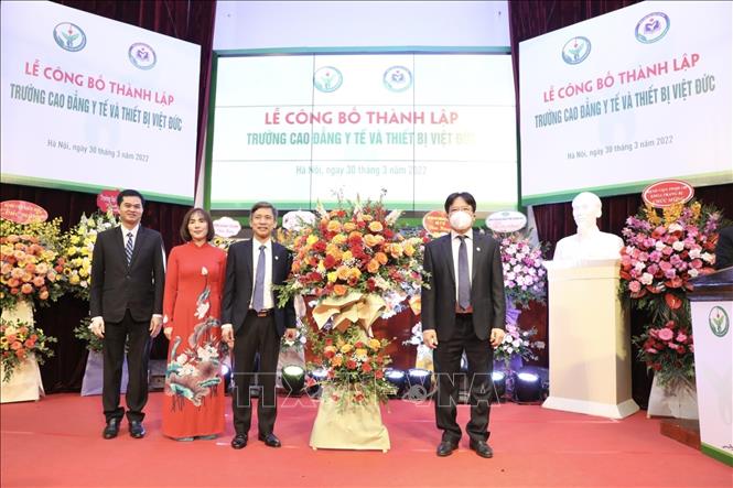 Trong ảnh: Giám đốc bệnh viện Hữu nghị Việt Đức Trần Bình Giang tặng hoa chúc mừng ban giám hiệu trường Cao đẳng Y tế và Thiết bị Việt Đức. Ảnh: Minh Quyết - TTXVN