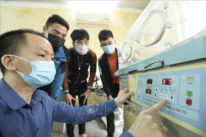 Trong ảnh: Giảng viên hướng dẫn sinh viên học thực hành với thiết bị lồng ấp trẻ sơ sinh. Ảnh: Minh Quyết - TTXVN