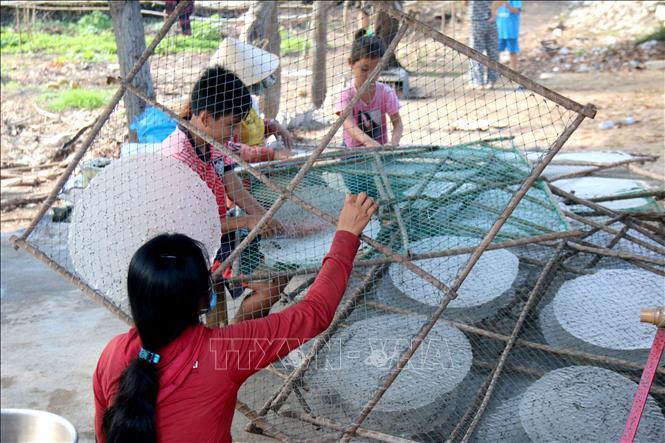 Trong ảnh: Gỡ bánh sau khi bánh tráng đã được phơi khô. Ảnh: Nguyễn Thanh - TTXVN