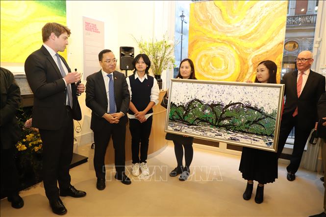 Họa sĩ Xèo Chu tặng bức tranh cho Thái Tử Charles. Ảnh: Vân Hải - PV TTXVN tại London