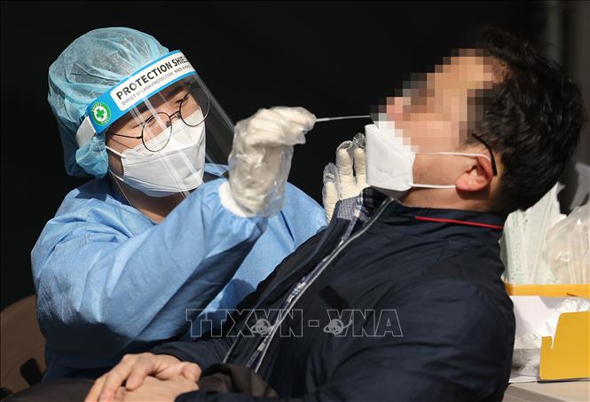 Trong ảnh: Nhân viên y tế lấy mẫu xét nghiệm COVID-19 cho người dân  tại Seoul, Hàn Quốc. Ảnh: YONHAP/TTXVN
