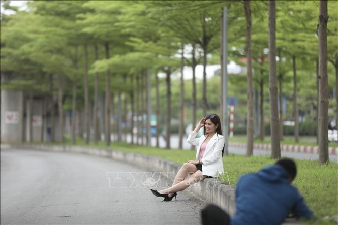 Nhiều người đến đây chụp ảnh dưới những tán bàng xanh mướt. Ảnh: Minh Quyết - TTXVN