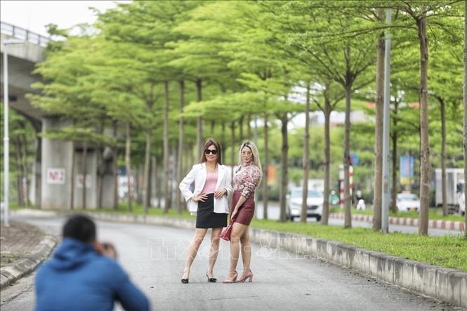 Nhiều người đến đây chụp ảnh dưới những tán bàng xanh mướt. Ảnh: Minh Quyết - TTXVN
