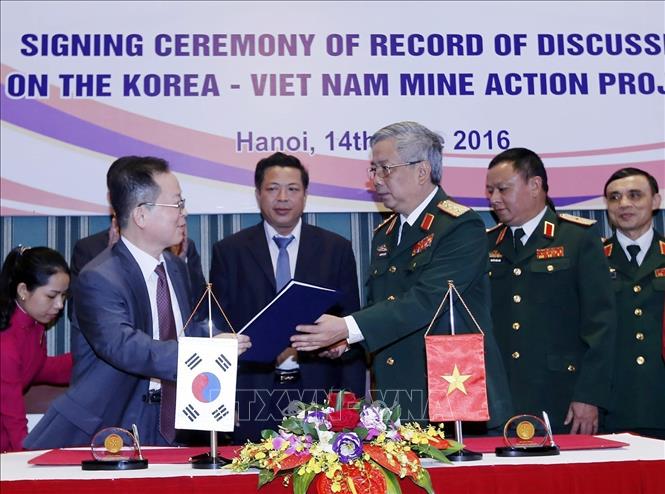 Cộng đồng các nhà tài trợ quốc tế và các tổ chức phi chính phủ đã có những hỗ trợ quý báu về trang thiết bị, kinh phí cho hoạt động khắc phục hậu quả bom, mìn ở Việt Nam. Trong ảnh: Bộ Quốc phòng phối hợp với Cơ quan Hợp tác quốc tế Hàn Quốc tại Việt Nam (KOICA) ký biên bản thảo luận dự án 