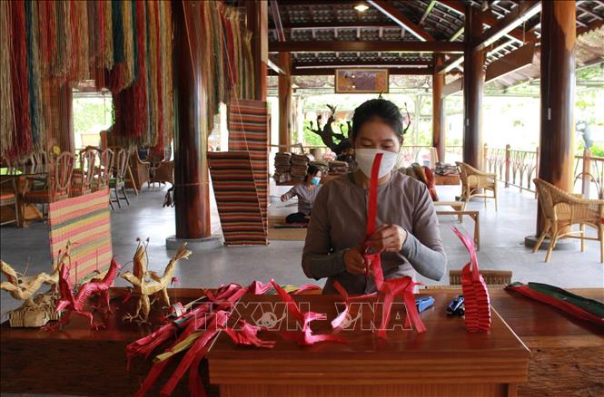 Trong ảnh: Thợ thủ công xếp giấy tạo hình các con vật phục vụ khách du lịch tham quan, mua làm đồ lưu niệm. Ảnh: Phan Sáu - TTXVN
