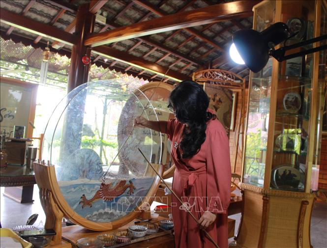 Trong ảnh: Thợ thủ công chế tác tranh cát tại không gian làng nghề Trường Sơn. Ảnh: Phan Sáu - TTXVN
