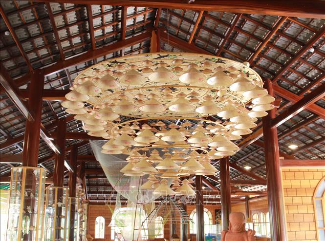 Trong ảnh: Tác thành tác phẩm nghệ thuật từ nón lá, được trưng bày trong không gian làng nghề Trường Sơn. Ảnh: Phan Sáu - TTXVN