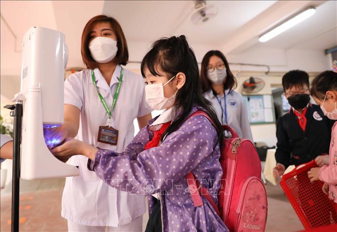 Công tác phân luồng, đo thân nhiệt, sát khuẩn tay cho học sinh được trường Tiểu học Thăng Long, quận Hoàn Kiếm thực hiện chu đáo. Ảnh: Thanh Tùng - TTXVN 