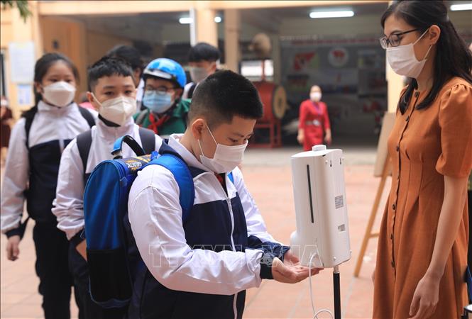 Trong ảnh: Học sinh khối lớp 6 đo thân nhiệt và sát khuẩn tay trong ngày đầu tiên đến Trường THCS Quỳnh Mai, quận Hai Bà Trưng. Ảnh: Hoàng Hiếu - TTXVN 
