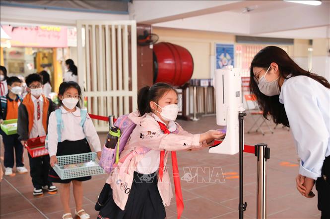 Công tác phân luồng, đo thân nhiệt, sát khuẩn tay cho học sinh được trường Tiểu học Thăng Long, quận Hoàn Kiếm thực hiện nghiêm túc. Ảnh: Thanh Tùng - TTXVN 