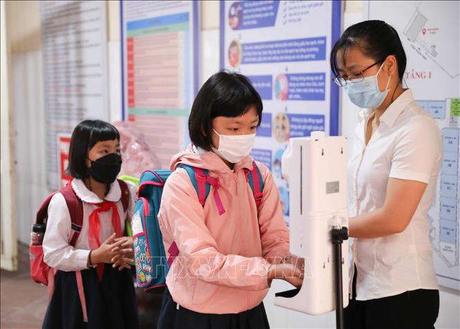 Công tác phân luồng, đo thân nhiệt, sát khuẩn tay cho học sinh được trường Tiểu học Thăng Long, quận Hoàn Kiếm thực hiện chu đáo. Ảnh: Thanh Tùng - TTXVN 