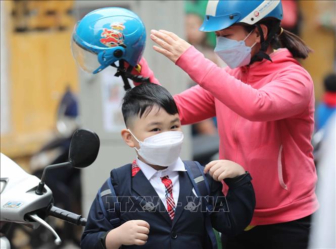Các bậc phụ huynh chăm lo cho con trẻ khi tới trường trở lại. Ảnh: Thanh Tùng - TTXVN 