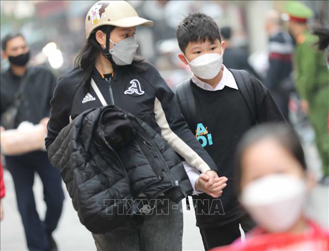 Các bậc phụ huynh chăm lo cho con trẻ khi tới trường trở lại. Ảnh: Thanh Tùng - TTXVN 