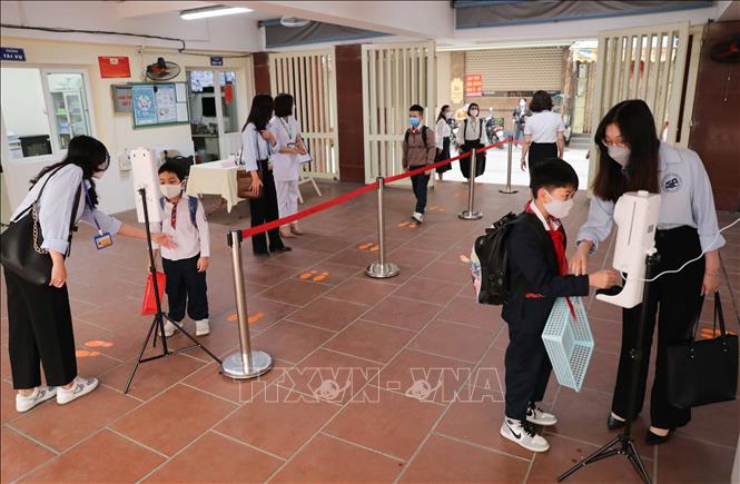 Công tác phân luồng, đo thân nhiệt, sát khuẩn tay cho học sinh được trường tiểu học Thăng Long, quận Hoàn Kiếm thực hiện chu đáo. Ảnh: Thanh Tùng - TTXVN 