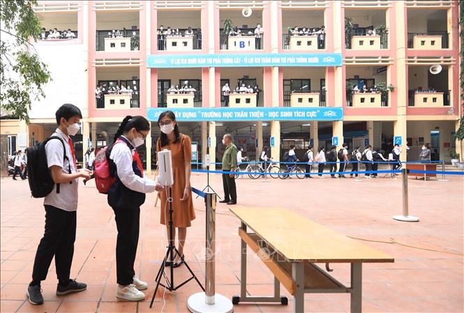 Trong ảnh: Trường Trong ảnh: Trường THCS Quỳnh Mai tổ chức đo thân nhiệt và sát khuẩn tay cho học sinh trước khi lên lớp. Ảnh: Hoàng Hiếu - TTXVN 