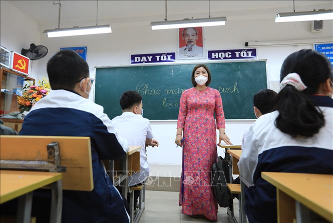 Cô giáo Mai Thu Hiền - chủ nhiệm lớp 6D Trường THCS Quỳnh Mai hướng dẫn học sinh trong ngày đầu tiên đi học trực tiếp tại trường. Ảnh: Hoàng Hiếu - TTXVN