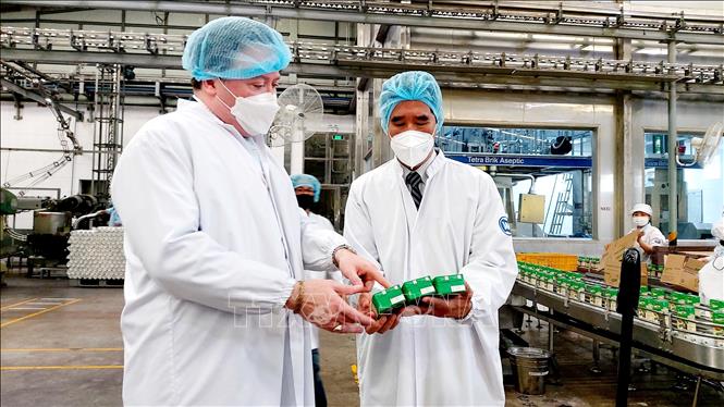 Trong ảnh: Lãnh đạo Vinamilk giới thiệu với Đại sứ Marc Evans Knapper một sản phẩm sữa của công ty. Ảnh: Thu Hiền - TTXVN