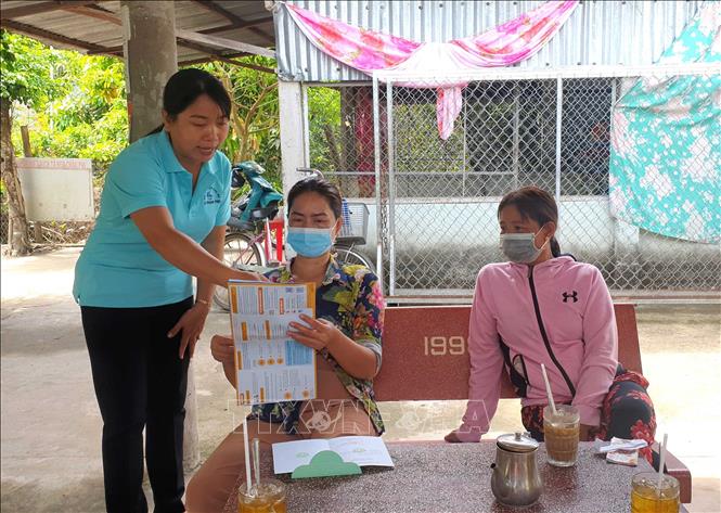 Bà Trần Thị Anh Thư, Chủ tịch Hội Liên hiệp phụ nữ xã Phong phú, huyện Cầu Kè tuyên truyền chính sách bảo hiểm xã hội tự nguyện đến phụ nữ xã. Ảnh: Thanh Hòa - TTXVN