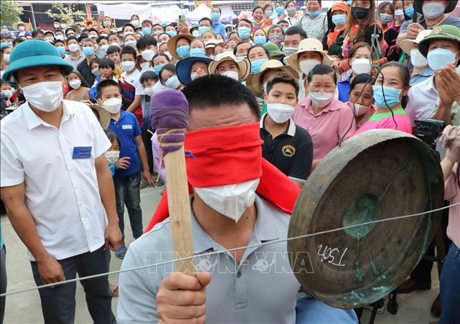 Du khách tham gia trò chơi bịt mắt, đánh chiêng. Ảnh: Nguyễn Oanh-TTXVN.