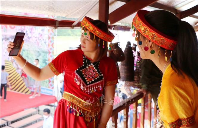 Hai du khách thích thú lưu lại khoảnh khắc khi tham quan lễ hội. Ảnh: Nguyễn Oanh-TTXVN.