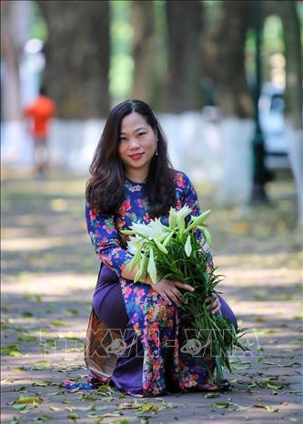 Người dân Thủ đô chụp ảnh với hoa loa kèn. Ảnh: Tuấn Đức - TTXVN