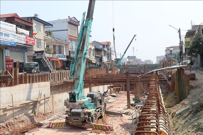 Tron ảnh: Tranh thủ thời tiết thuận lợi, nhà thầu thi công đẩy nhanh tiến độ thi công công trình. Ảnh: Hoàng Nguyên - TTXVN