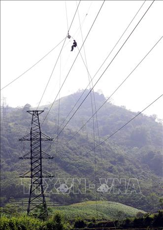 Thi công kéo dây trên tuyến tại vị trí cột 21-22 trên địa bàn huyện Bảo Thắng. Ảnh: Huy Hùng – TTXVN
