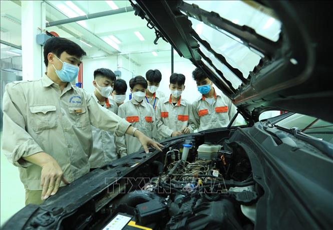 Trong ảnh: Giảng viên Nguyễn Thanh Tùng  (Khoa Công nghệ ô tô) hướng dẫn các chi tiết ô tô cho học viên lớp trung cấp K50. Ảnh: Hoàng Hiếu - TTXVN