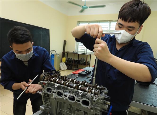 Trong ảnh: Sinh viên K13 (Khoa công nghệ ô tô) thực hành tháo lắp, sửa chữa động cơ ô tô. Ảnh: Hoàng Hiếu - TTXVN