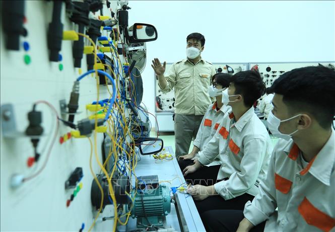 Trong ảnh: Giảng viên Nguyễn Quang Hiển (Khoa Công nghệ ô tô) hướng dẫn các  chi tiết và sửa chữa thiết bị điện ô tô cho sinh viên K13. Ảnh: Hoàng Hiếu - TTXVN 