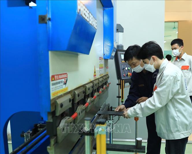 Trong ảnh: Trong ảnh: Học viên lớp K50 (Trung cấp kỹ thuật cơ khí) thực hành trên máy gập kim loại. Ảnh: Hoàng Hiếu - TTXVN