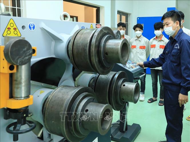 Trong ảnh: Giảng viên Khoa kỹ thuật cơ khí hướng dẫn học viên lớp K50 (hệ Trung cấp) các bước thao tác để an toàn khi sử dụng máy uốn ống. Ảnh: Hoàng Hiếu - TTXVN