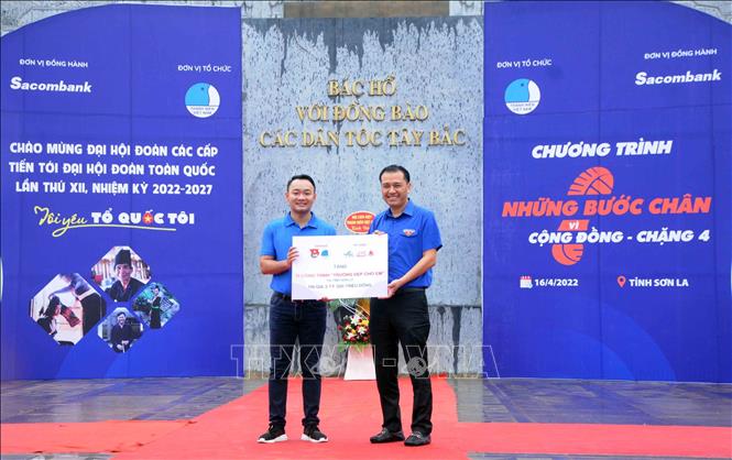 Chủ tịch Hội Liên hiệp Thanh niên Việt Nam tỉnh Sơn La Nguyễn Duy Dũng (bên trái) nhận biểu trưng 13 điểm “Trường đẹp cho em” do Ban tổ chức trao tặng. Ảnh: Quang Quyết-TTXVN