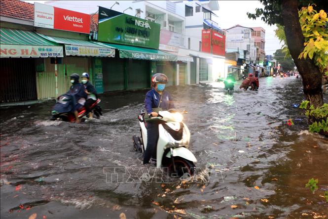Nước ngập sâu trên đường Hưng Đạo Vương, phường 1, thành phố Vĩnh Long khiến giao thông gặp nhiều khó khăn. Ảnh: Phạm Minh Tuấn-TTXVN