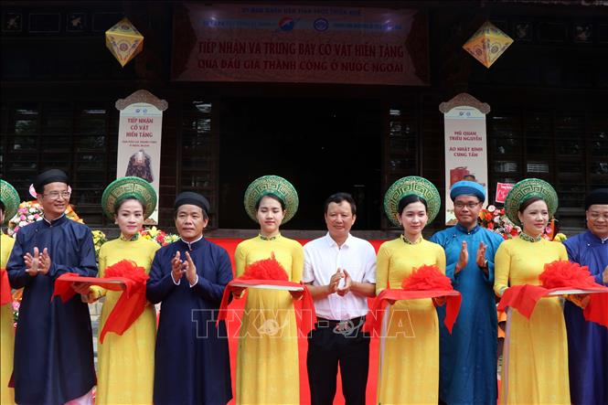 Trong ảnh: Các đại biểu cắt băng khai mạc triển lãm trưng bày hai cổ vật triều Nguyễn. Ảnh: Đỗ Trưởng - TTXVN

