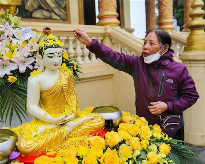 Nghi thức tắm tượng phật bằng nước ướp hương, gột rửa những điều không may mắn năm cũ để sang năm mới mọi sự được như ý. Ảnh: Tuấn Đức - TTXVN