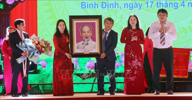 Phó chủ tịch nước Võ Thị Ánh Xuân tặng ảnh chân dung Chủ tịch Hồ Chí Minh và hoa cho lãnh đạo Huyện ủy, UBND huyện Hoài Ân. Ảnh: Kha Phạm – TTXVN