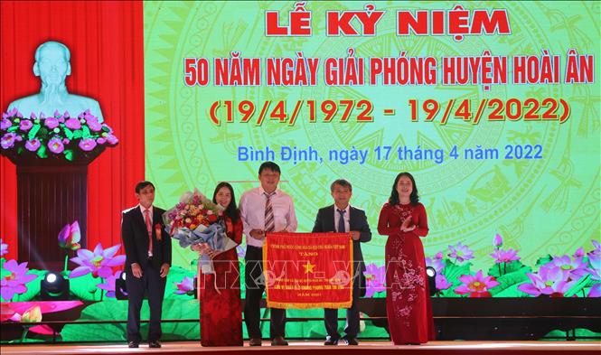 Phó chủ tịch nước Võ Thị Ánh Xuân trao Cờ thi đua của Chính phủ cho lãnh đạo Huyện ủy, UBND huyện Hoài Ân. Ảnh: Kha Phạm – TTXVN