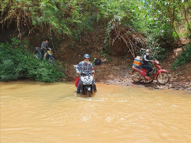 Trong ảnh: Người dân và phương tiện vượt sông để qua lại giữa hai tỉnh Bình Phước và Đồng Nai. Ảnh: K GỬIH -TTXVN