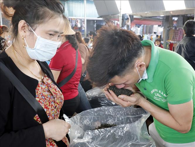 Trong ảnh: Người mua thử hương của chè khô. Ảnh: Trần Việt - TTXVN
