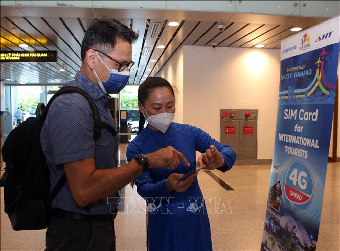 A foreign visitor  receives a free SIM card at Da Nang International Airport. VNA Photo: Trần Lê Lâm
