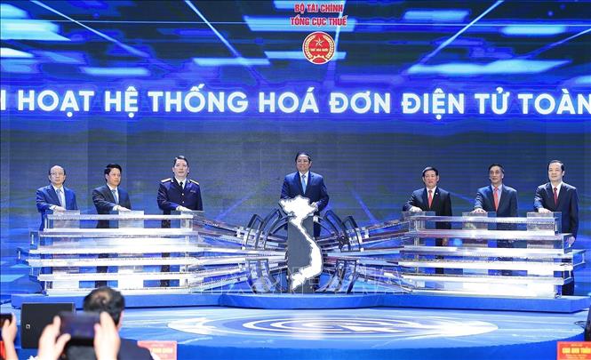 Prime Minister Pham Minh Chinh (C) and delegates launch the national e-invoice system. VNA Photo: Dương Giang