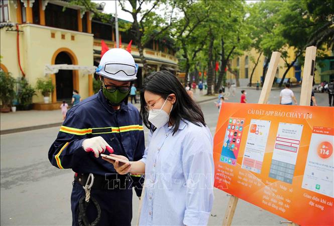 Trong ảnh: Cán bộ, chiến sĩ cảnh sát PCCC và CNCH quận Hoàn Kiếm hướng dẫn các em học sinh cài đặt App báo cháy 114. Ảnh: Phạm Kiên - TTXVN