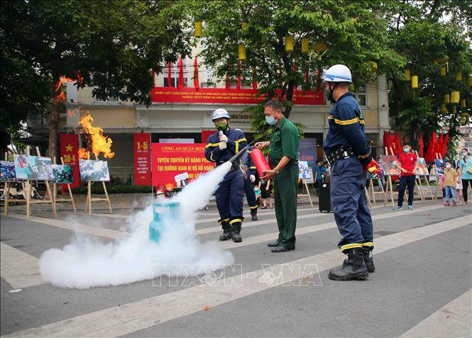 Trong ảnh: Cán bộ, chiến sĩ cảnh sát PCCC và CNCH quận Hoàn Kiếm hướng dẫn người dân sử dụng bình chữa cháy. Ảnh: Phạm Kiên - TTXVN